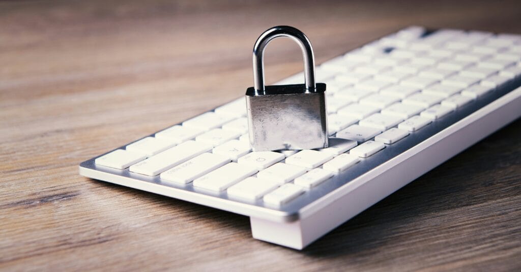A padlock resting on a white computer keyboard, symbolizing digital account security and authentication