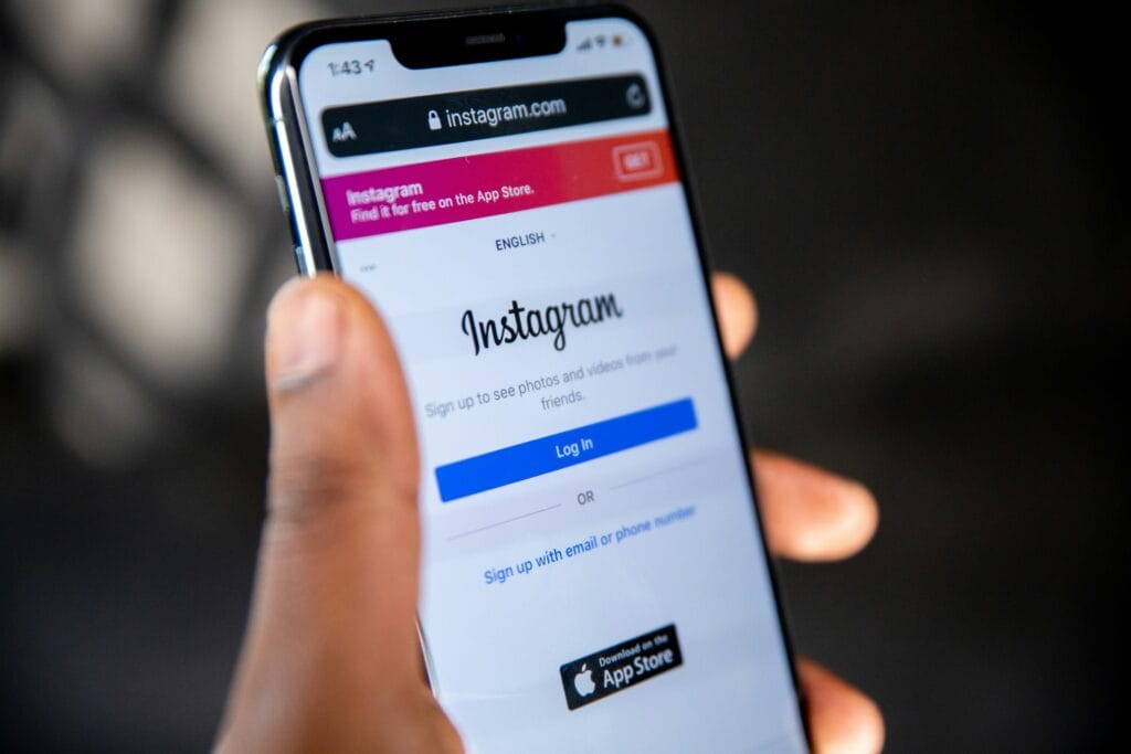 Hand holding a smartphone displaying the Instagram login page at instagram.com in a mobile browser