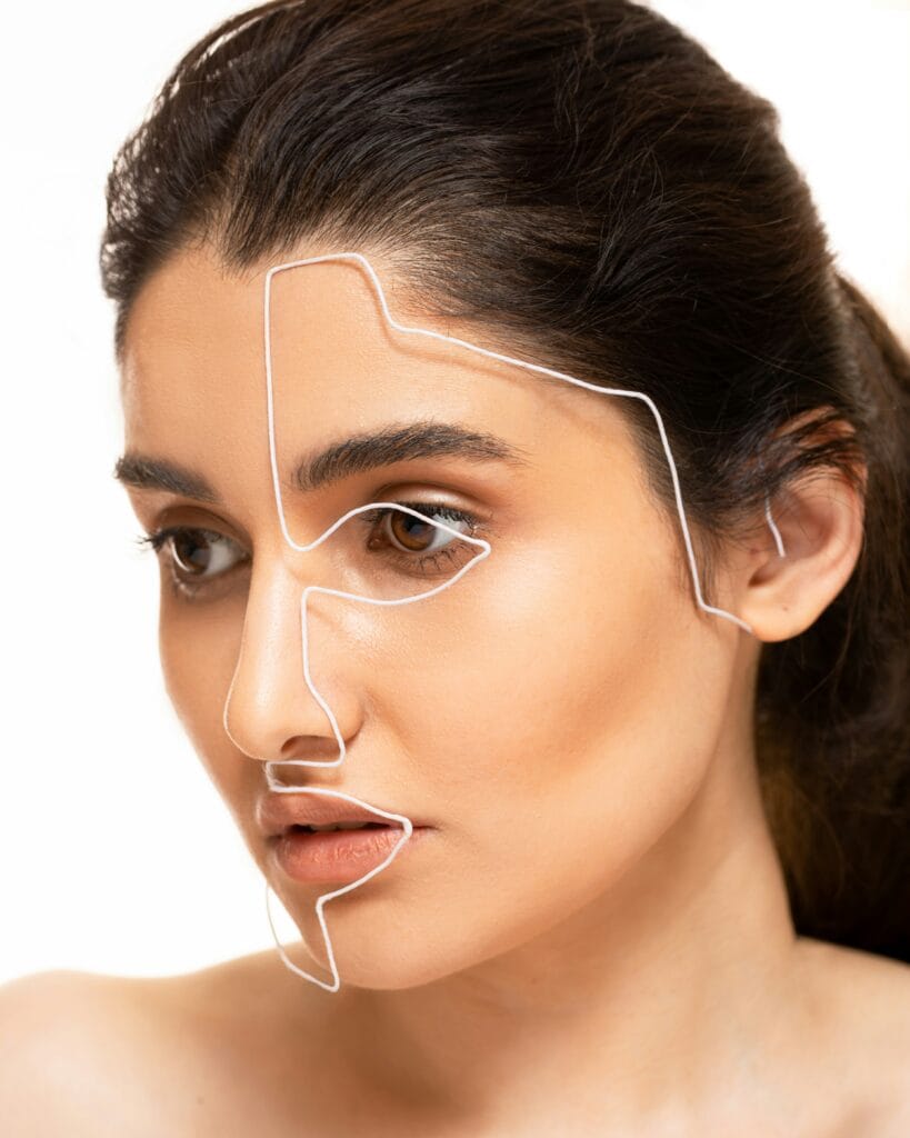 Woman's face with a white outline tracing her facial contours to illustrate face shape analysis